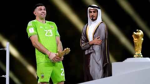 Der argentinische Torhüter Emiliano Martinez (l) jubelt mit dem Goldenen Handschuh, der ihn als besten Torhüter des Torhütern auszeichnet.