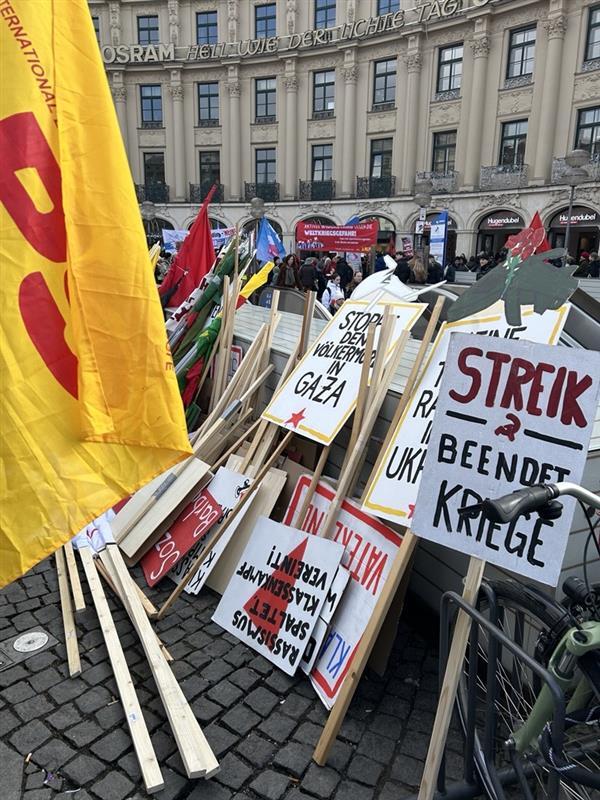 Auf Schildern der Demonstranten wird u. a. das Ende der Kriege in der Ukraine und im Gazastreifen gefordert. Auf Schildern der Demonstranten wird u. a. das Ende der Kriege in der Ukraine und im Gazastreifen gefordert.
