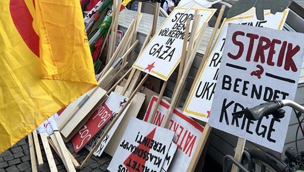 Auf Schildern der Demonstranten wird u. a. das Ende der Kriege in der Ukraine und im Gazastreifen gefordert. Auf Schildern der Demonstranten wird u. a. das Ende der Kriege in der Ukraine und im Gazastreifen gefordert.