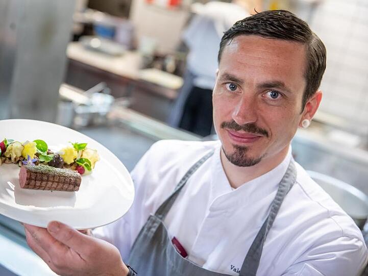 Valentin Rottner, Sternekoch aus Nürnberg, präsentiert in seinem Restaurant Waidwerk Rehrücken mit Steinpilzen, Topinambur, Selleriepüree und Passionsfrucht auf einem Teller. Foto: Daniel Karmann/dpa/Archivbild