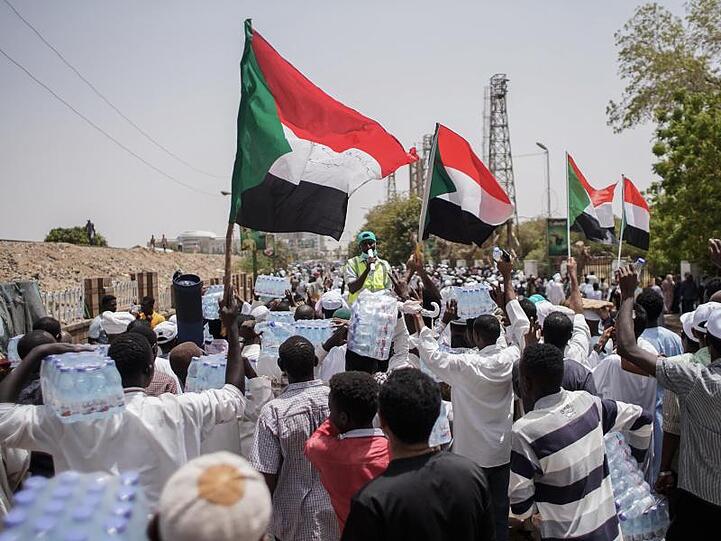 Demonstranten schwenken beim Marsch Richtung Verteidigungsministerium Nationalflaggen. Auch nach dem Sturz von Präsident Omar al-Baschir kommt der Sudan nicht zur Ruhe.