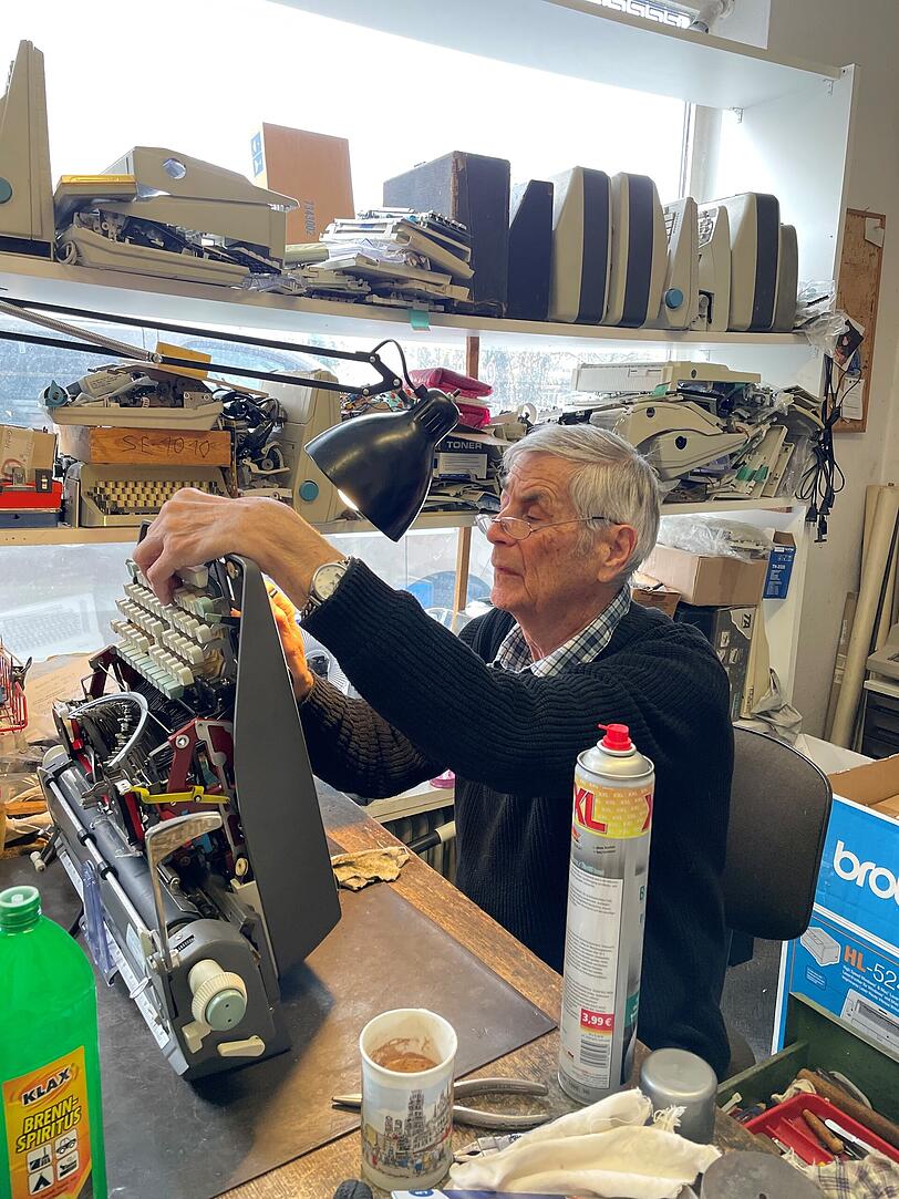 Karl-Heinz Schulze (81) reinigt das Innere einer Schreibmaschine.