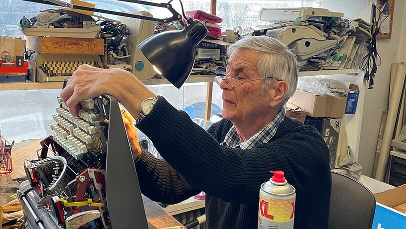 Karl-Heinz Schulze (81) reinigt das Innere einer Schreibmaschine.