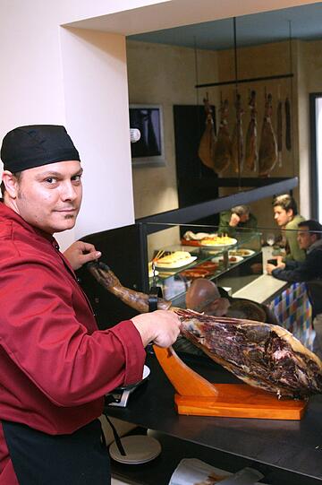 Auf die Qualität kommt es an: Juan aus Bilbao schneidet Schinken vom Iberico-Schwein für seine Gäste.
