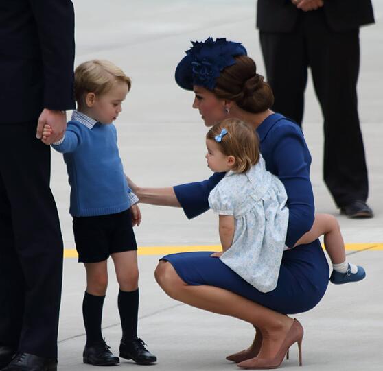 Der kleine George trägt eine kurze Hose und einen langen blauen Pullover.