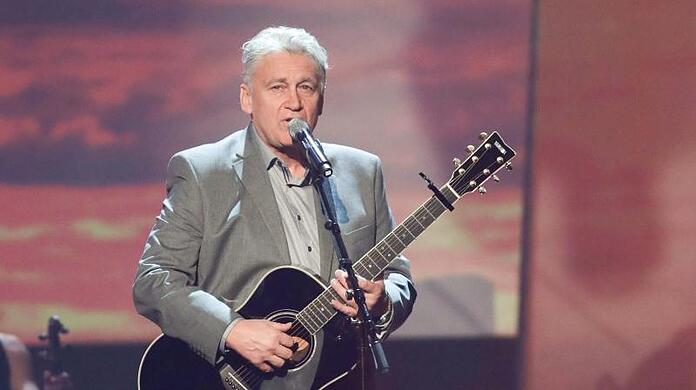 Der Musiker Rainhard Fendrich steht auf der Bühne. Foto: Jörg Carstensen/dpa/Archivbild