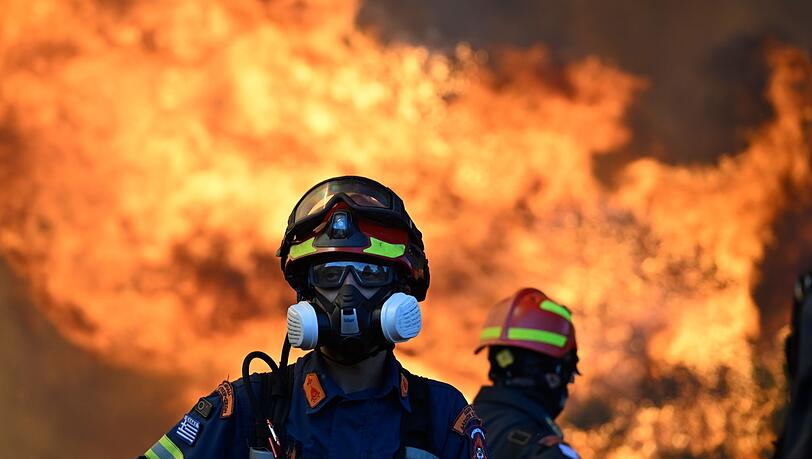 Ein Feuerwehrmann steht vor den lodernden Flammen nordwestlich von Athen.