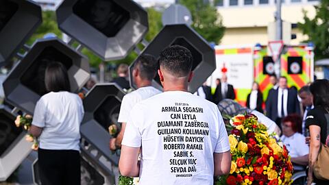 Besucher tragen T-Shirts mit den Namen der Opfer.