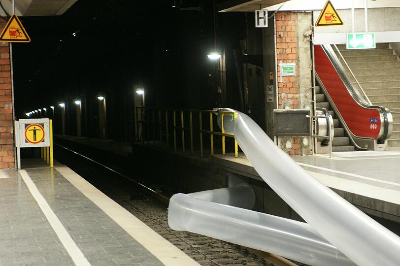 Die Baustelle: Im Hintergrund sieht man den abgeschlossenen Gleisbereich, in dem gearbeitet wird. Durch die Schläuche wird die asbesthaltige Luft abgesaugt.