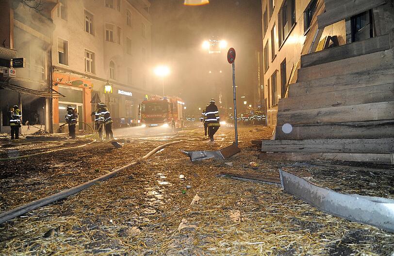 Feuer, Rauch, zerborstene Fenster - nach der Sprengung der Bombe hat die Feuerwehr viel zu tun: Umherfliegendes Stroh hatte Brände verursacht.