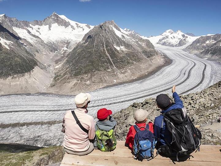 Wanderer blicken auf den Großen Aletschgletscher. Foto: Walter Bieri/KEYSTONE/dpa/Symbolbild