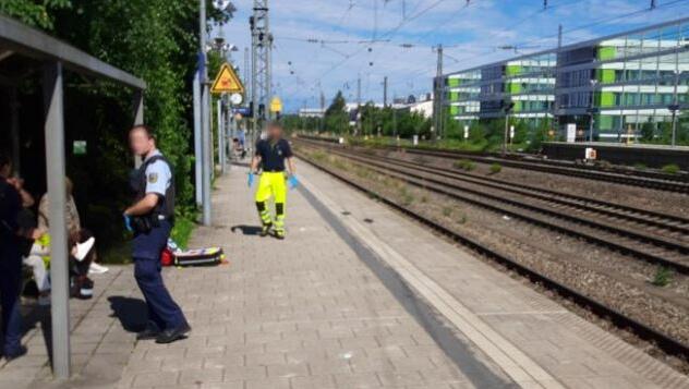 Ein Bundespolizist und ein Helfer nach dem Unfall am Bahnsteig der Haltestelle Heimeranplatz.