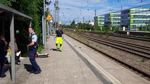 Ein Bundespolizist und ein Helfer nach dem Unfall am Bahnsteig der Haltestelle Heimeranplatz.