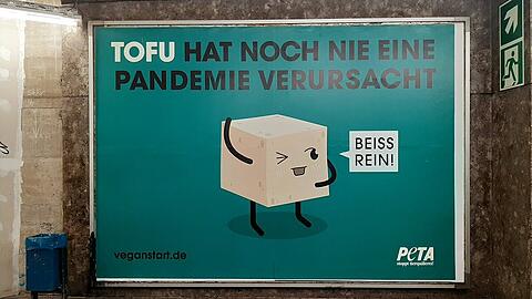 Um auf die enge Verbindung zwischen der Fleischindustrie und der Entstehung tödlicher Zoonosen wie COVID-19 aufmerksam zu machen, hat Peta an zwei Standorten in München zwei Großplakate platziert.