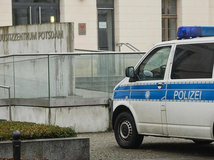Nach einer Bombendrohung von Rechtsextremisten steht ein Polizeifahrzeug am Justizzentrum Potsdam.
