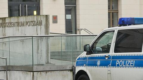 Nach einer Bombendrohung von Rechtsextremisten steht ein Polizeifahrzeug am Justizzentrum Potsdam.