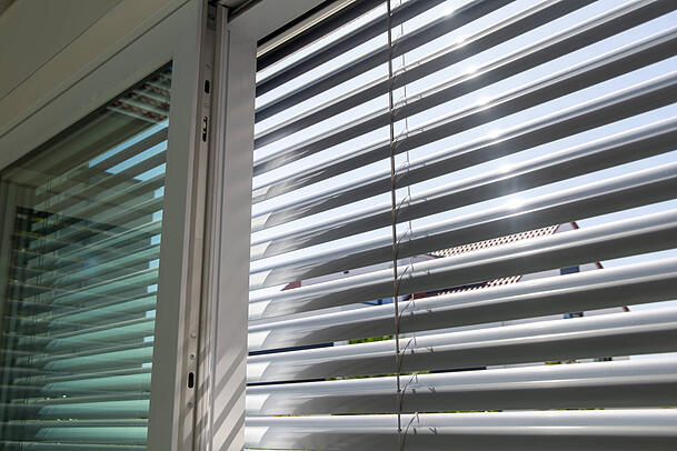 Außenjalousie an einem großen Schiebefenster. Die sind besonders effektiv, weil die Wärme so erst gar nicht in den Raum hineingelangt. Außenjalousie an einem großen Schiebefenster. Die sind besonders effektiv, weil die Wärme so erst gar nicht in den Raum hineingelangt.