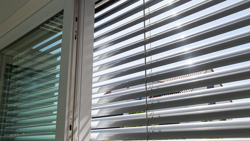 Außenjalousie an einem großen Schiebefenster. Die sind besonders effektiv, weil die Wärme so erst gar nicht in den Raum hineingelangt. Außenjalousie an einem großen Schiebefenster. Die sind besonders effektiv, weil die Wärme so erst gar nicht in den Raum hineingelangt.