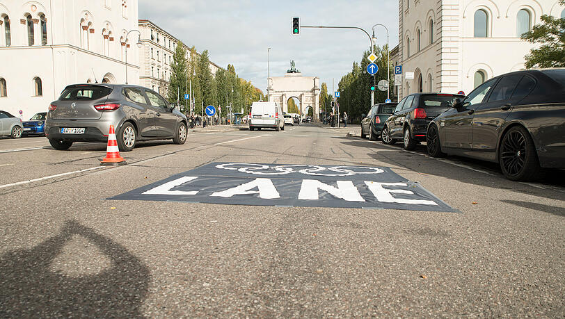 Wenn Olympia in München stattfindet, würden Fahrspuren für die Athleten gesperrt. Davor warnt das Nolympia-Bündnis mit einer Aktion auf der Ludwigstraße.