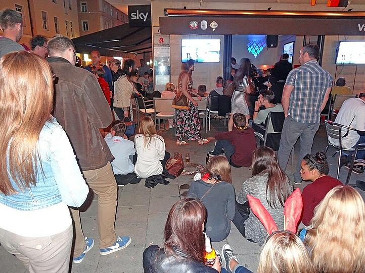 Vor der "Vanilla Lounge" an der Leopoldstraße verfolgen Fans das Deutschland-Spiel gegen die USA zur Not halt am Boden sitzend.