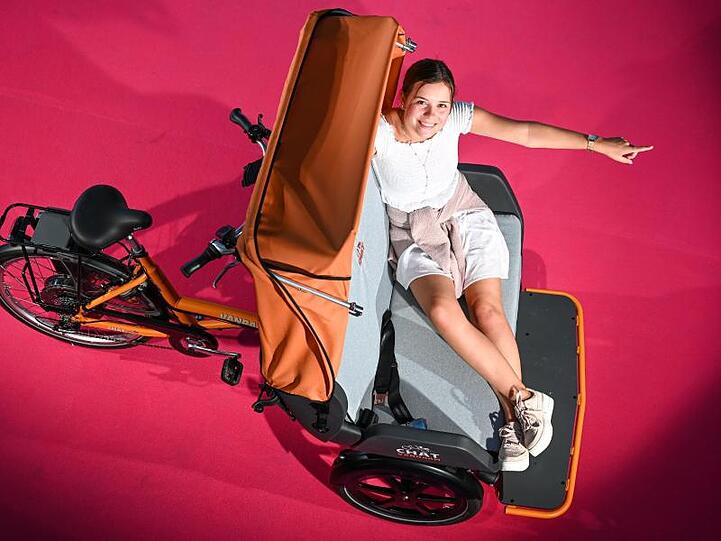 Model Christiane sitzt vor der Eröffnung der Eurobike 2019 auf einer Rikscha des Herstellers Van Raam.
