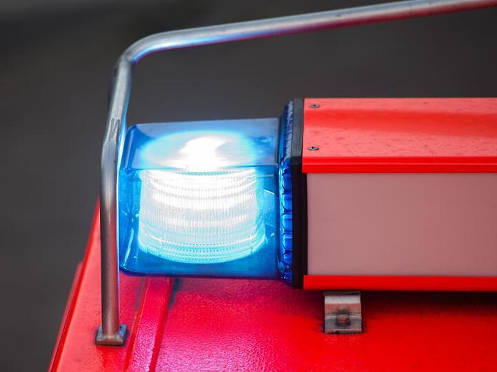 Ein Löschfahrzeug der Feuerwehr steht nach einer Übung mit eingeschaltetem Blaulicht an der Feuerwache. Foto: Daniel Bockwoldt/Archivbild