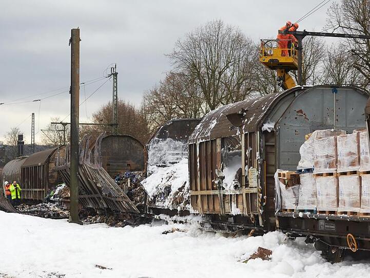 Nach dem Brand von vier Güterzugwaggons sind Bahnmitarbeiter mit der Bergung und der Reparatur der Strecke beschäftigt.