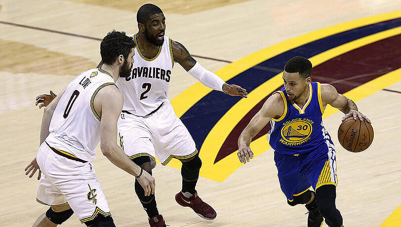 Warriors-Guard Stephen Curry (rechts) wird von den Cavaliers Kevin Love (links) und Kyrie Irving in Empfang genommen. Warriors-Guard Stephen Curry (rechts) wird von den Cavaliers Kevin Love (links) und Kyrie Irving in Empfang genommen.