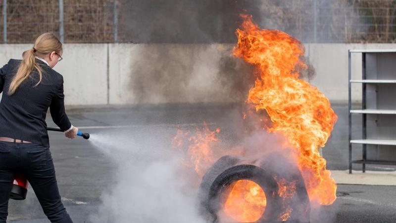 Eine Frau löscht ein Feuer mit einem Wassernebel-Feuerlöscher. Foto: Daniel Karmann Eine Frau löscht ein Feuer mit einem Wassernebel-Feuerlöscher. Foto: Daniel Karmann