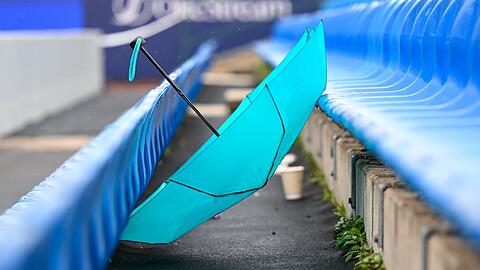 Ein Regenschirm liegt auf einer Tribüne.