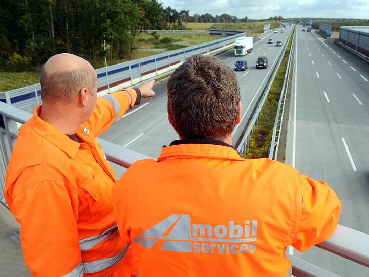 Mitarbeiter des privaten Konsortiums A1 mobil stehen auf einer Brücke über der A1 zwischen Hamburg und Bremen.