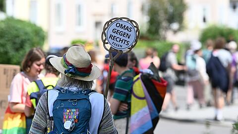 Eine Demonstrantin h&auml;lt ein Schild von "Omas gegen Rechts" in die H&ouml;he.