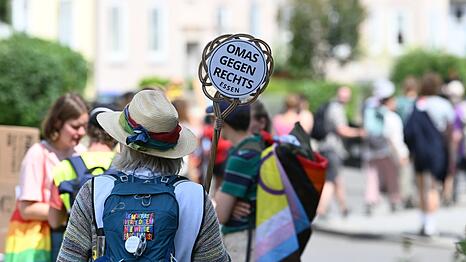 Eine Demonstrantin h&auml;lt ein Schild von "Omas gegen Rechts" in die H&ouml;he.