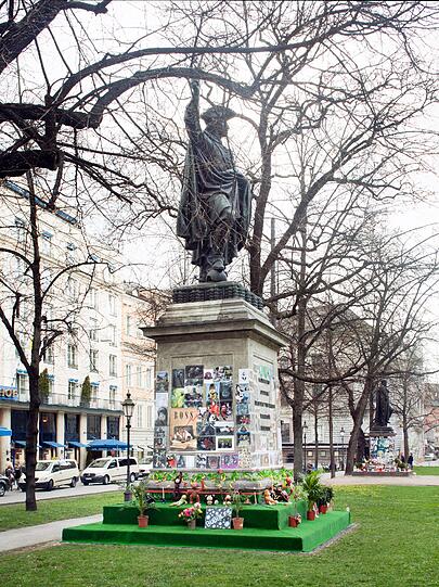 Der britische Künstler David Shrigley hat ein Denkmal für Bubbles, den Lieblingsaffen Michael Jacksons entworfen. "Bubblesplatz" befindet sich direkt neben dem Monument für Orlando di Lasso auf dem Promenadeplatz, das die Fans von Michael Jackson zu einem Erinnerungsort für den Popstar umgewidmet haben.
