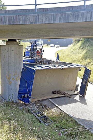 Der Kieslaster blieb an der Brücke hängen. Der Fahrer hatte vergessen, die Laderampe wieder einzufahren.