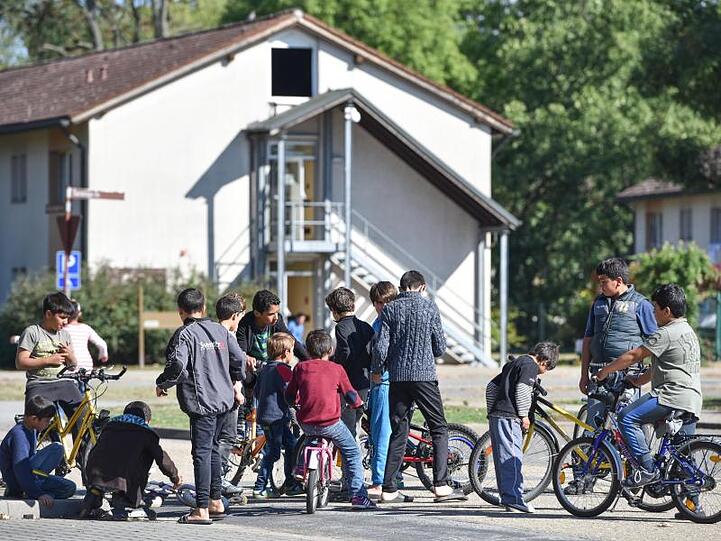 Flüchtlingskinder im Patrick-Henry-Village in Heidelberg vor einem ehemaligen Kasernengebäude.