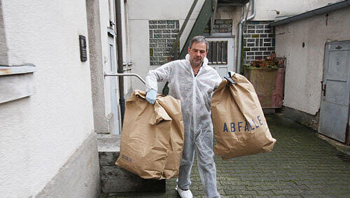 Ein Mitarbeiter der Spurensicherung transportiert in großen Müllsäcken Material vom Tatort zur Auswertung ins Labor ab. Ein Mitarbeiter der Spurensicherung transportiert in großen Müllsäcken Material vom Tatort zur Auswertung ins Labor ab.