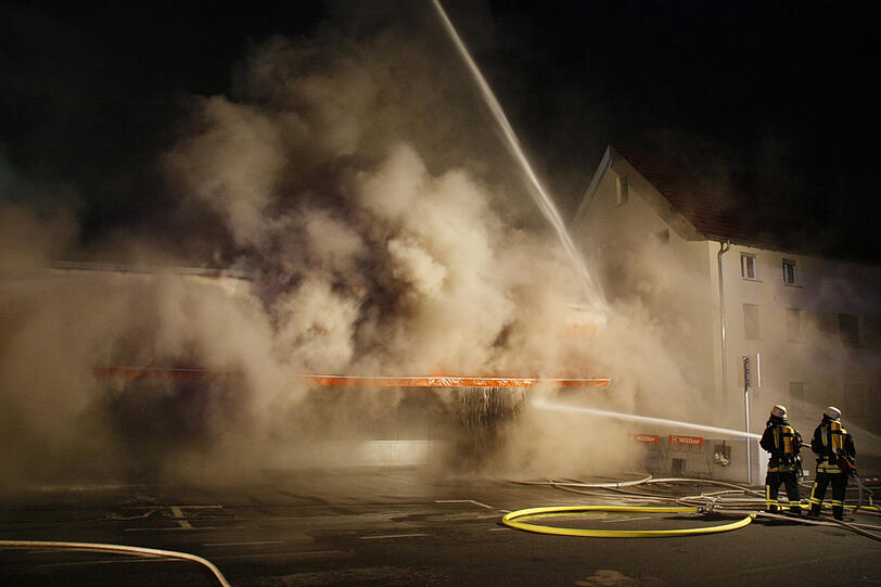 Feuerwehrleute kämpfen in der Nacht zum Freitag in Neu-Ulm gegen das Feuer in einem Drogeriemarkt. Beim dem Brand ist ein Millionenschaden entstanden.