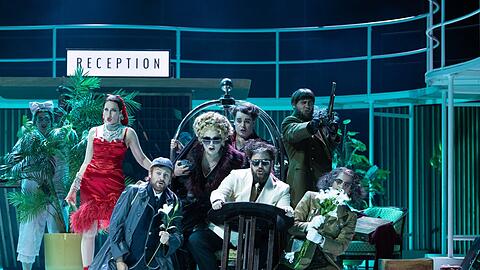 R&eacute;ka Krist&oacute;f (Corinna), Andreja Zidaric (Comtesse Folleville), Ludwig Mittelhammer (Lord Sidney), Anna Agathonos (Marchesa Melibea), Andr&eacute;s Agudelo (Chevalier Belfiore), Matija Meic (Don &Aacute;lvaro), Gyula Rab (Graf Libenskof), Timos Sirlantzis (Don Profondo) in Rossinis &bdquo;Reise nach Reims&ldquo;.