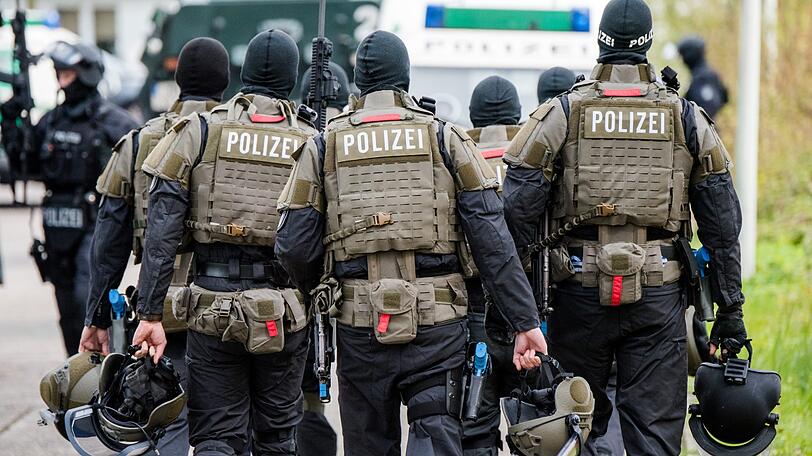 Schwer bewaffnete Polizisten gehen während einer Anti-Terror-Übung zu ihren Fahrzeugen.