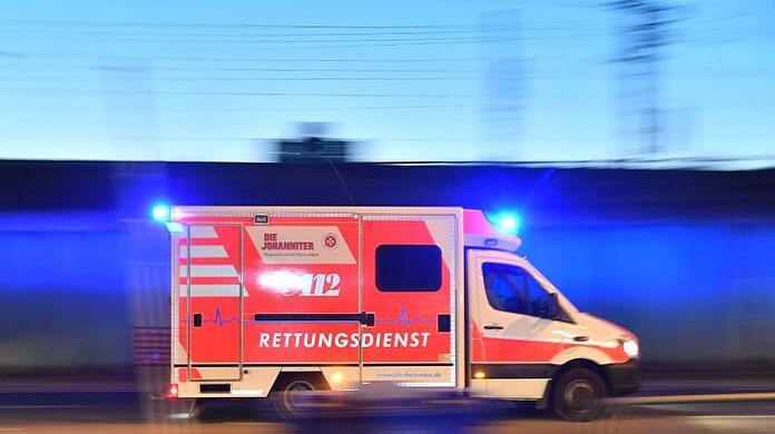 Ein Rettungswagen ist mit eingeschaltetem Blauchlicht im Einsatz.