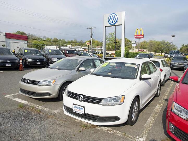 Autos der Marke Volkswagen stehen auf dem Hof eines Händlers.