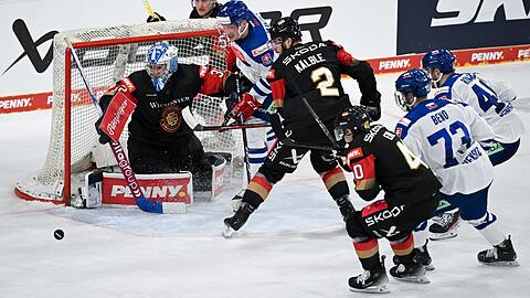 Die Spieler von Deutschland und von der Slowakei kämpfen vor dem Tor um den Puck.