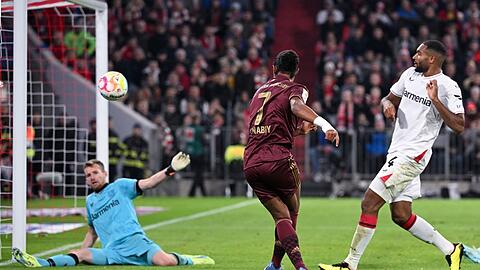 Serge Gnabry (M) von München schießt auf das Tor von Lukas Hradecky von Leverkusen.