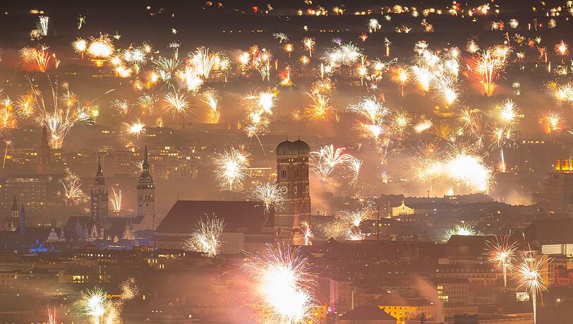 Silvesterfeuerwerk erhellt den Himmel über der Innenstadt.