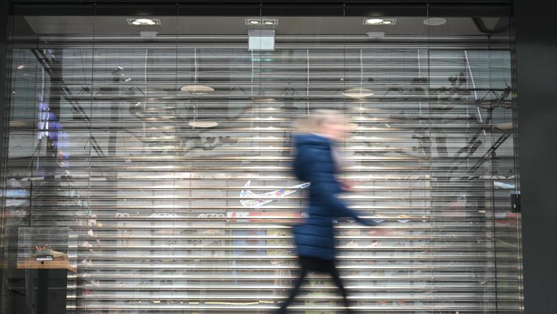 Eine Frau geht auf der Frankfurter Einkaufsmeile Zeil an einem Geschäft vorbei, an dem noch das Rollgitter heruntergelassen ist. Durch die Corona-Krise droht vielen innerstädtischen Geschäften das Aus. Eine Frau geht auf der Frankfurter Einkaufsmeile Zeil an einem Geschäft vorbei, an dem noch das Rollgitter heruntergelassen ist. Durch die Corona-Krise droht vielen innerstädtischen Geschäften das Aus.