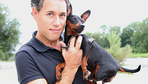 Burkhard Mayer mit seinem Zwergpinscher Wanja, dessen hintere Pfote noch immer bandagiert ist. Burkhard Mayer mit seinem Zwergpinscher Wanja, dessen hintere Pfote noch immer bandagiert ist.