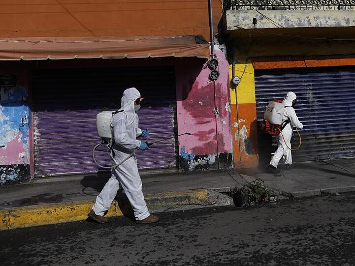 Coronavirus-Pandemie: In Mexiko-Stadt sprühen Arbeiter eine Desinfektionslösung auf die Straße.