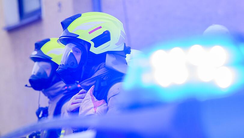 Feuerwehrleute stehen an einem Einsatzort.