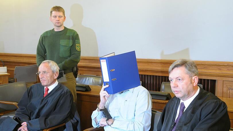 Der Angeklagte Guido N. (M) schützt sich zwischen seinen Anwälten Erhard Frank (l) und Malte Heise (r) mit einem Aktenordner vor dem Medieninteresse im Gerichtssaal des Landgerichts Leipzig. Der Angeklagte Guido N. (M) schützt sich zwischen seinen Anwälten Erhard Frank (l) und Malte Heise (r) mit einem Aktenordner vor dem Medieninteresse im Gerichtssaal des Landgerichts Leipzig.